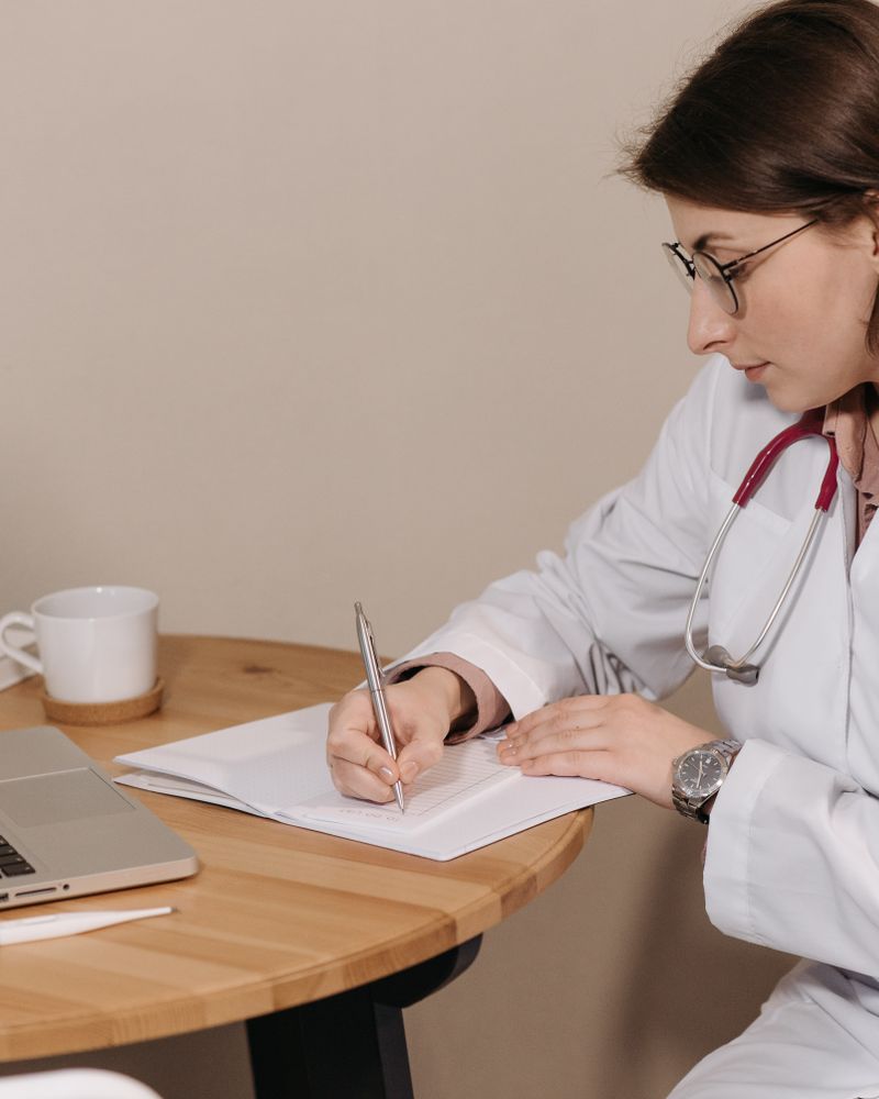 Medical and scientific writing: doctor writing clinical documents beside a laptop